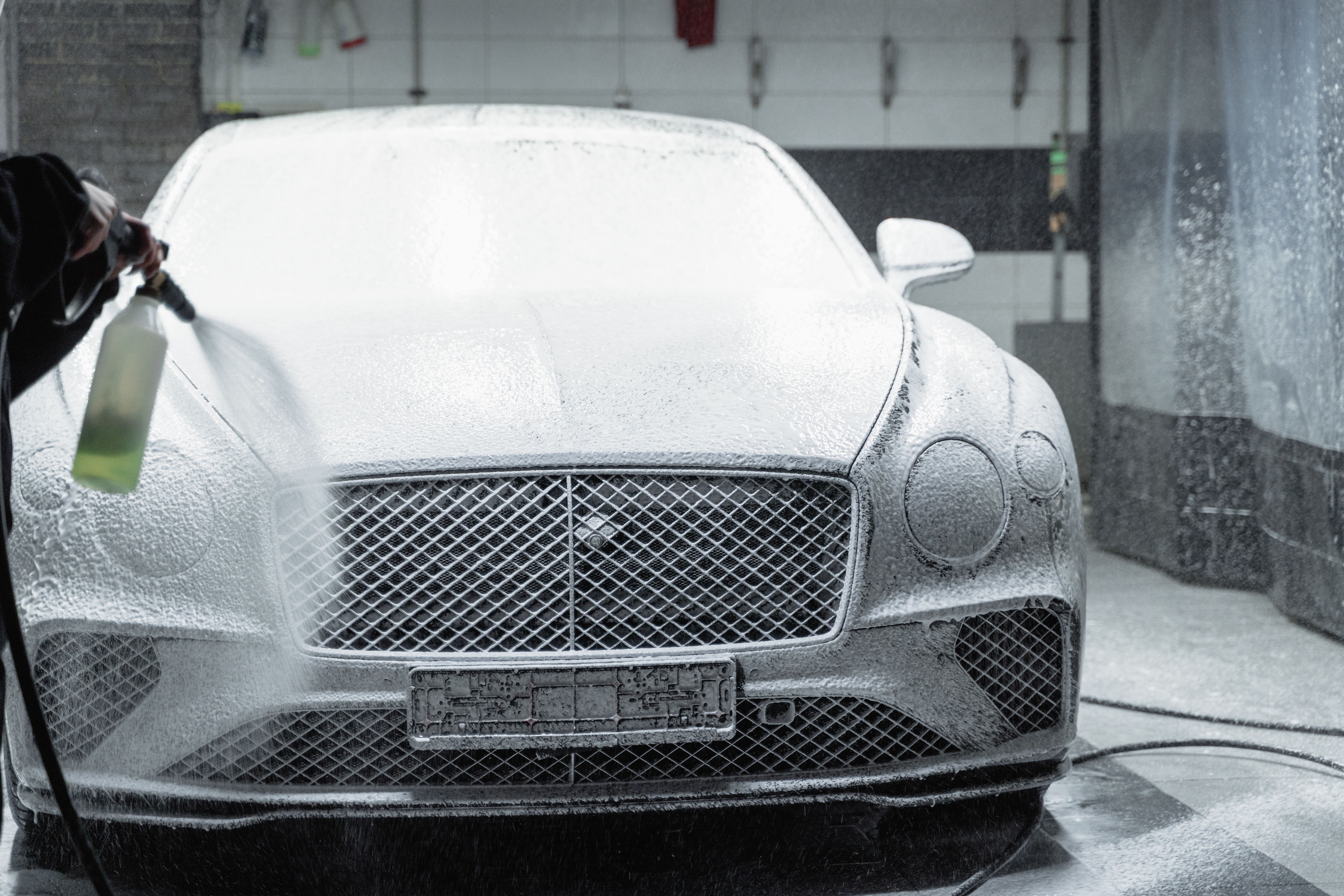 Luxury car covered in foam during an express wash